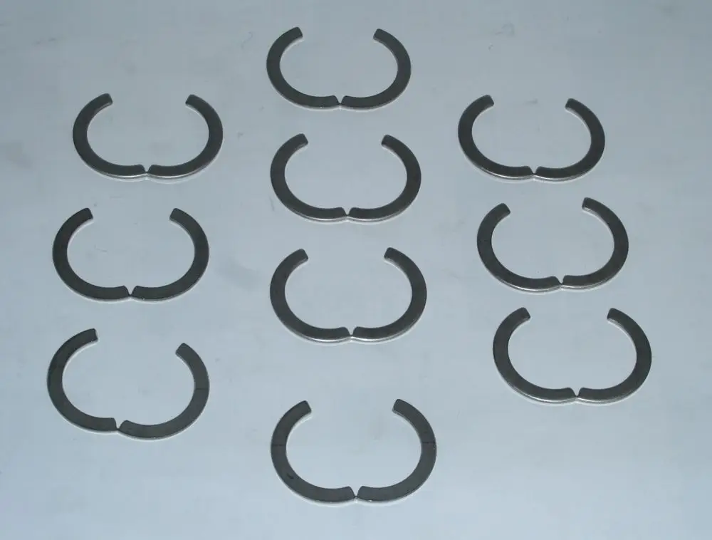 Zehn segmentförmige Ringe aus Metall, die typischerweise in Daikin-Produkten verwendet werden. Sie sind halbmondförmig und in einer ordentlichen Anordnung auf einer Fläche dargestellt.